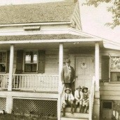 Photograph of Arthur Conan Doyle with his children, Denis, Adrian and Billie standing outside Edgar Allan Poe''s house at Fordham, New York in America